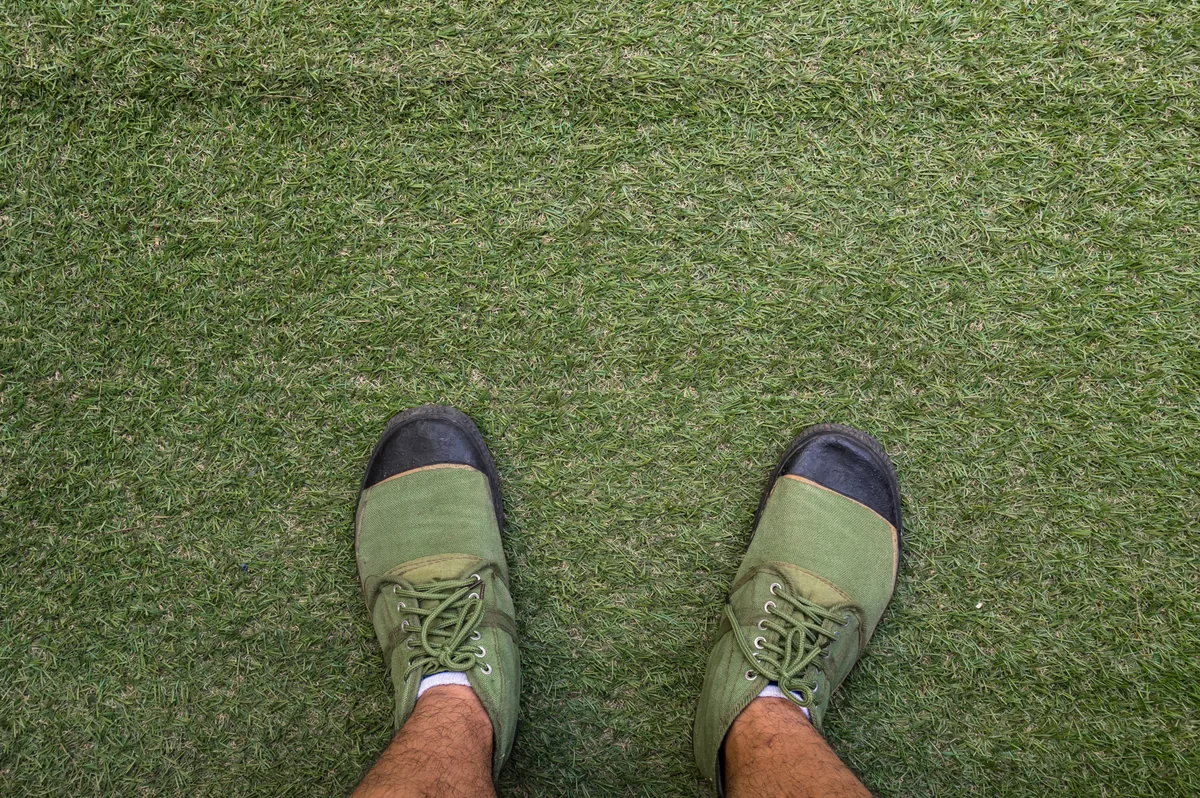 Técnico de Grupo Mundo Verde instalando pasto sintético profesionalmente en un jardín residencial de Querétaro